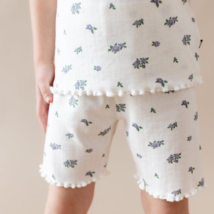 White pajama set with floral pattern on a beige background