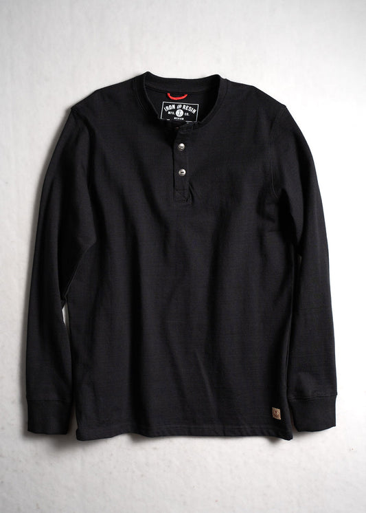 Black long-sleeve henley shirt with three buttons, laid flat on a light surface. Iron & Resin label visible inside the collar.