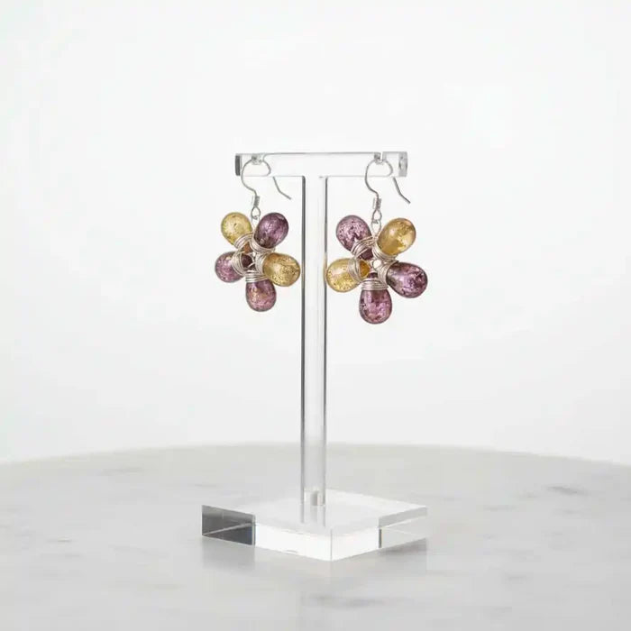Purple and Yellow Flower Sterling Silver Earrings displayed on a stand, showcasing their floral design and colorful glass beads.