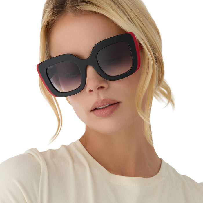 on model - female wearing diff eyewear x disney alice in wonderland queen of hearts square oversized sunglasses with a black and red acetate frame and grey gradient lenses front view