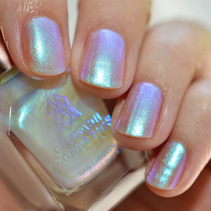 Close up shot of nails done with Radiance nail lacquer on medium skin tone holding the nail lacquer bottle