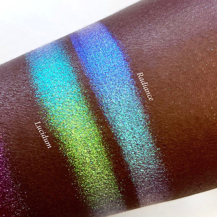 Top angled arm swatches on deep skin tone of Radiance Series 2 Iridescent Multichrome Eyeshadow shifts compared to Lucidum