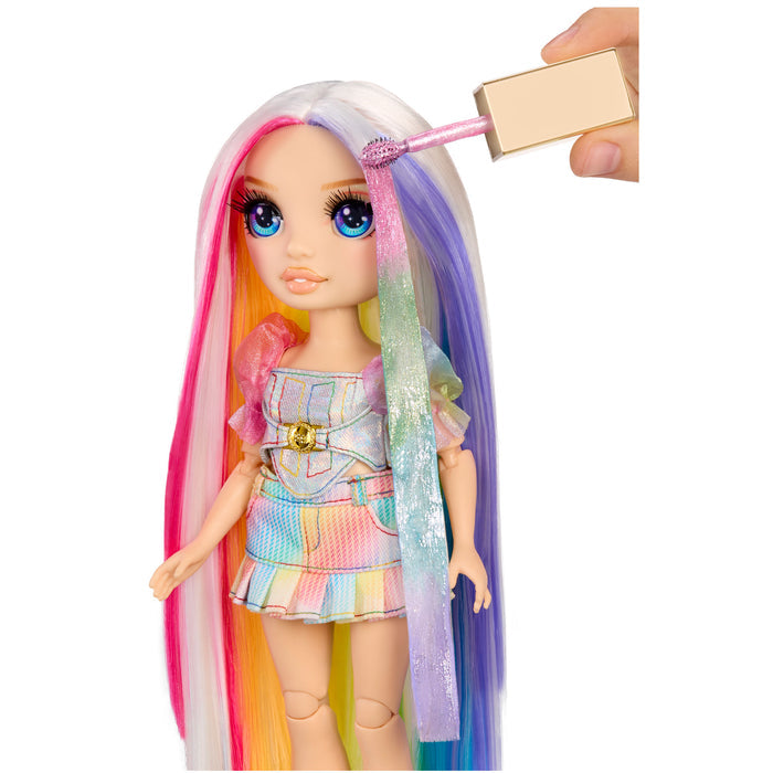 Toy doll with colorful hair being styled by a hand holding a color wand on a white background