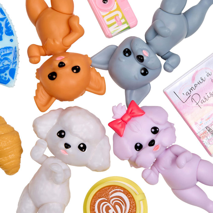 Collection of  four small dog figurines and a pink box with text on a white background