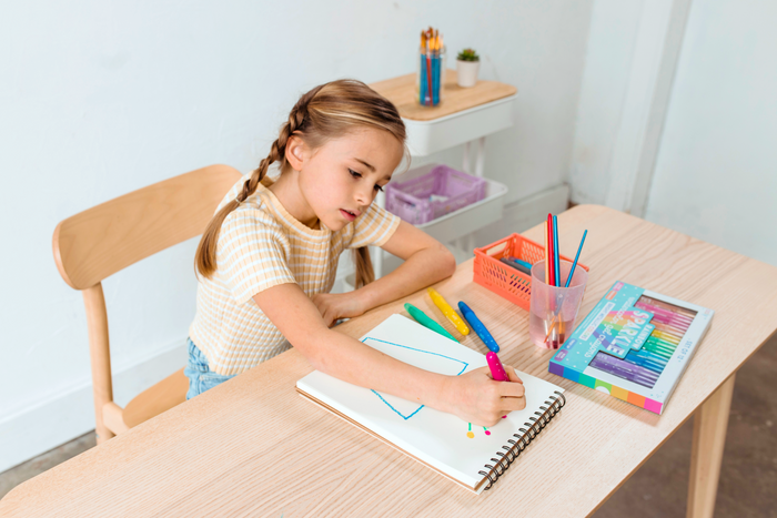 Girl coloring blue flower pot with OOLY Rainbow Sparkle Metallic Watercolor Gel Crayons