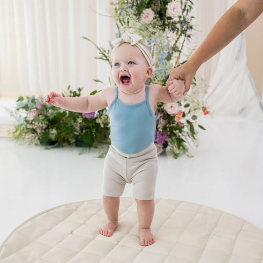 Infant wearing Kyte Baby Ribbed Biker Shorts in Oat