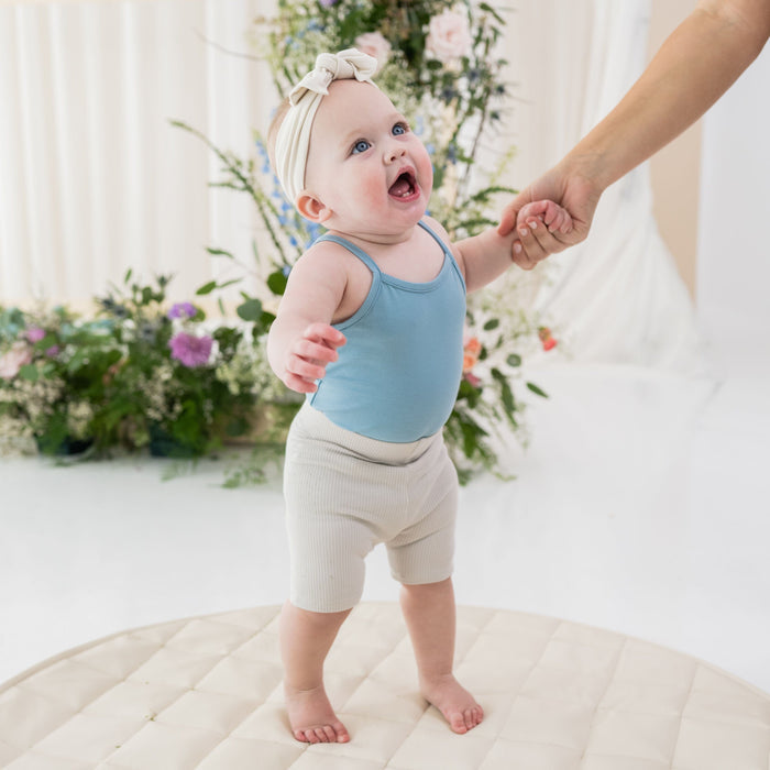 Girl wearing Kyte Baby Ribbed Toddler Bike Shorts in Oat