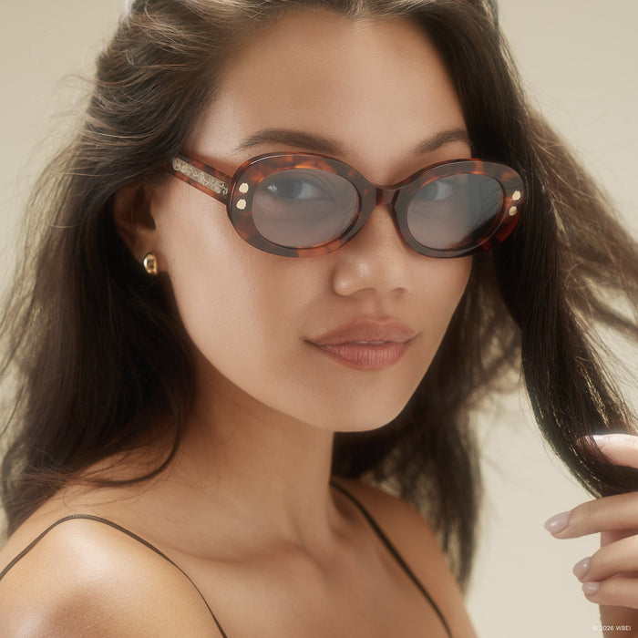 on model - female wearing diff eyewear x practical magic 2 sally oval sunglasses with a tortoise frame and light blue lenses front view