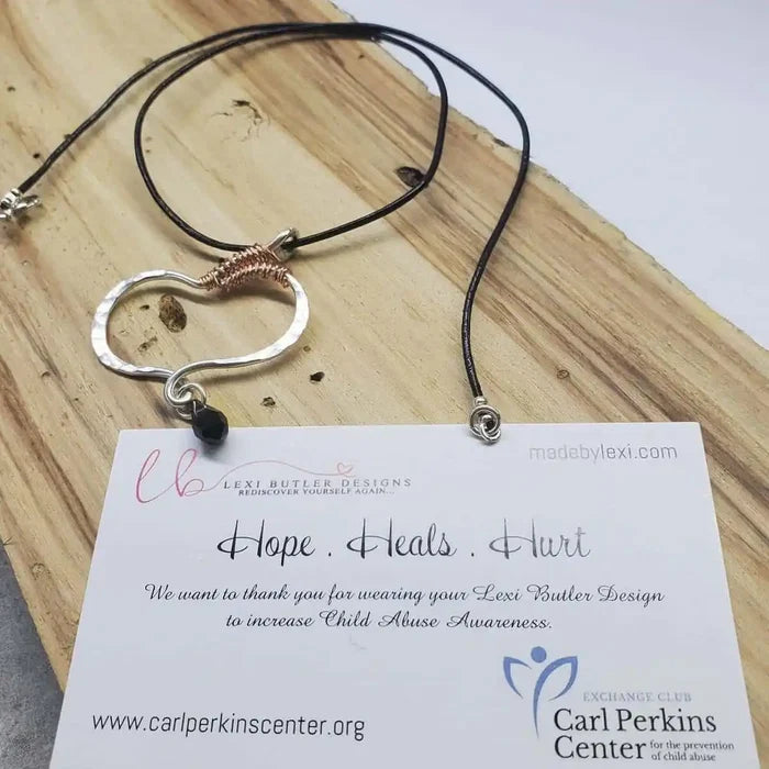 Sculpted Silver Butterfly Wing Child Abuse Survivor Necklace with braided leather cord and message card about child abuse awareness.