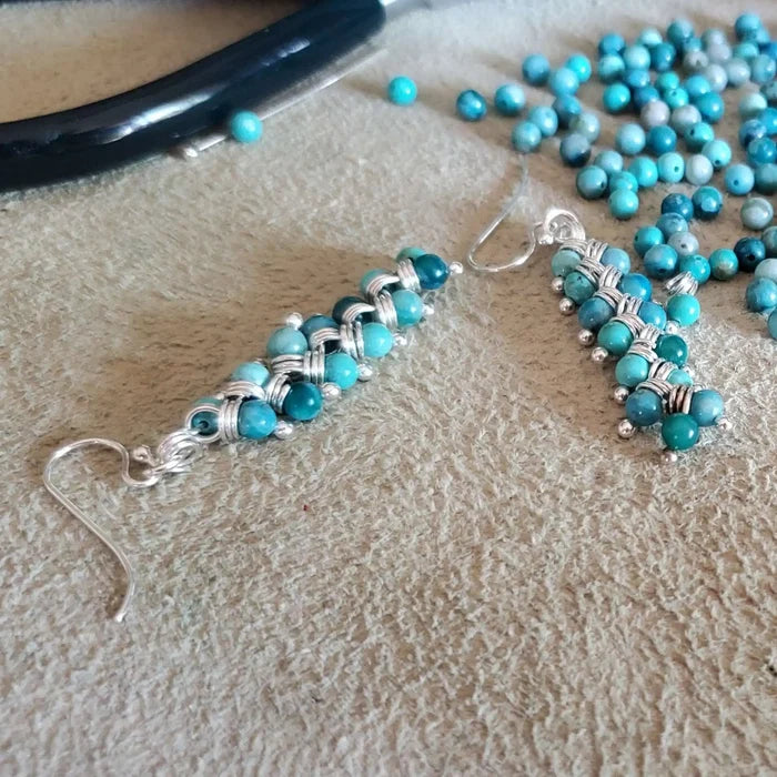 Seen On Jane The Virgin Silver Turquoise Wire Coil Earrings displayed with turquoise beads in background.