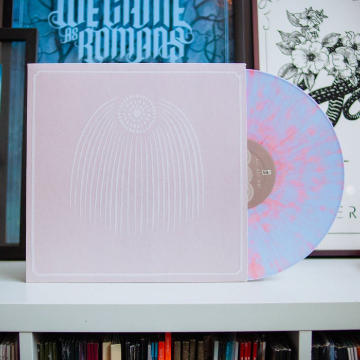 A pastel pink and lavender marbled All Get Out LP partially slides out of a pale pink cover with a minimalist arc design. This limited edition vinyl is shown on a white shelf, with framed artwork in the background.