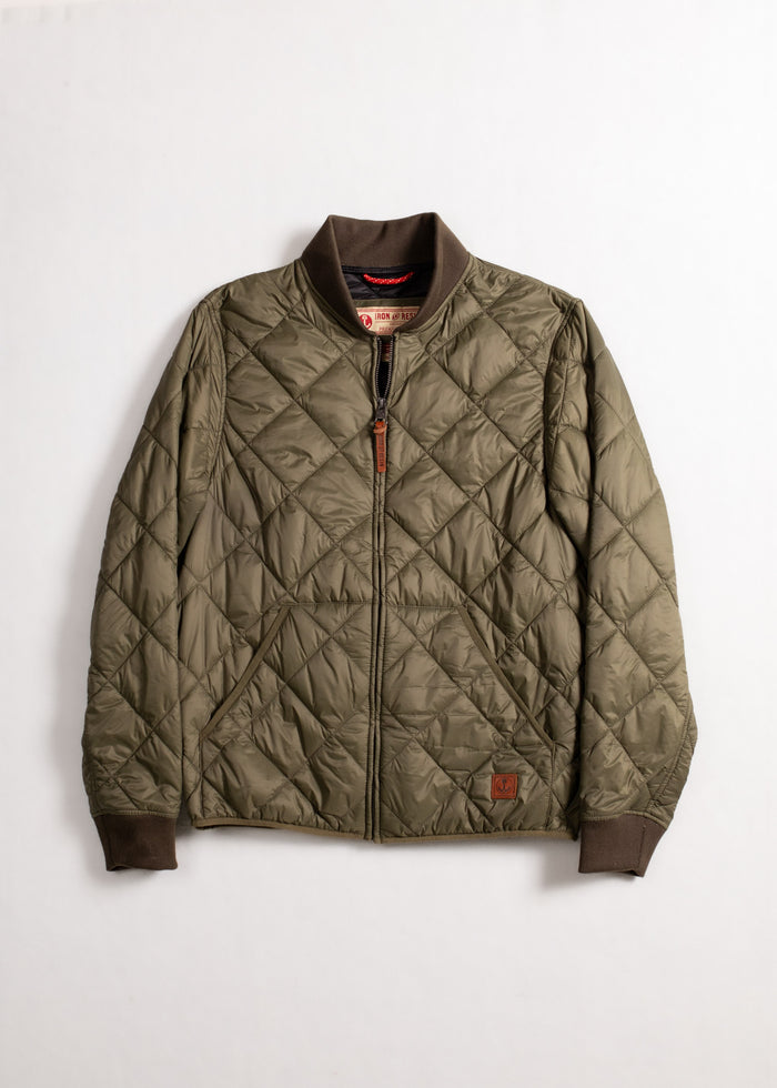 Olive green quilted jacket with brown cuffs and collar, featuring a front zipper and a small logo patch on the lower front.