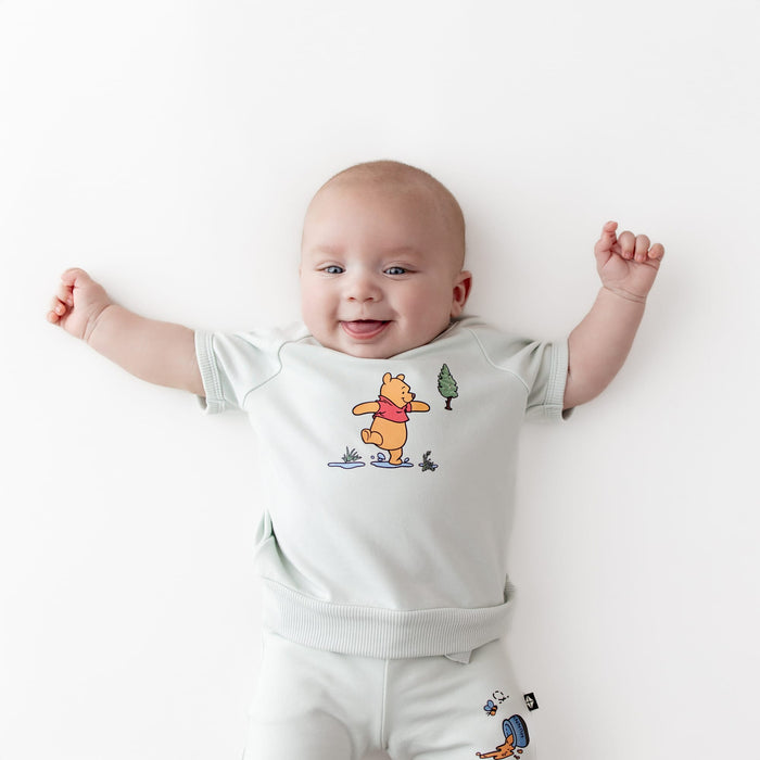 Close up of an infant wearing the Short Sleeve Jogger Set in Winnie the Pooh on Dew