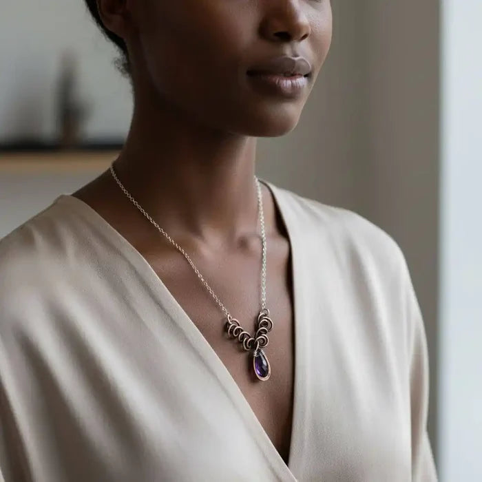 Silver and Copper Wire Sculpted Purple Crystal Drop Necklace worn by a model, showcasing its artisan elegance.