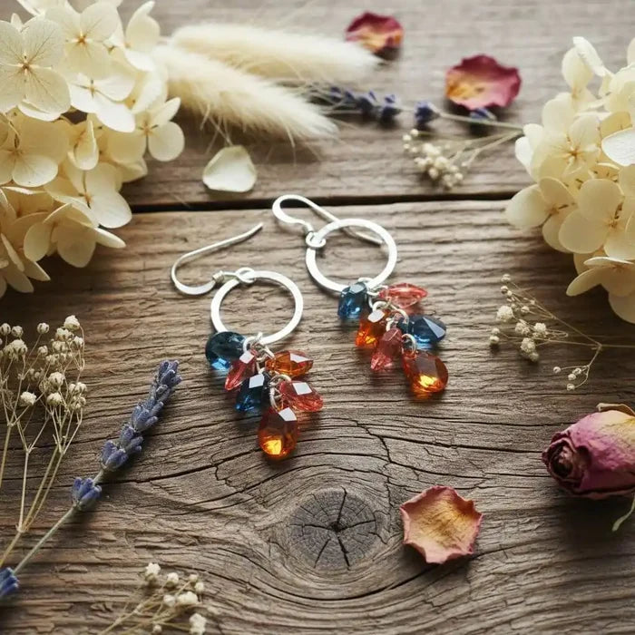 Silver Circle Multi Color Crystal Drop Dangle Earrings with colorful crystals on a wooden table decorated with flowers.