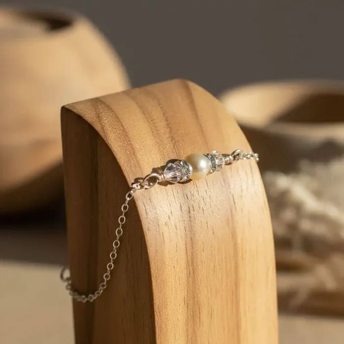 Silver Swarovski Crystal Pearl Bar Bridal Bracelet displayed on wooden stand, highlighting its elegance and design.