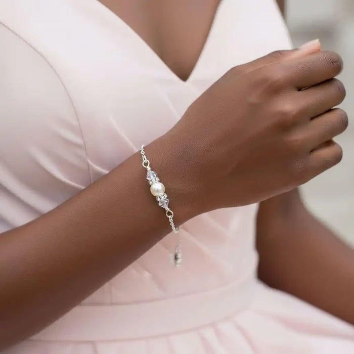 Silver Swarovski Crystal Pearl Bar Bridal Bracelet worn on a woman's wrist with a blush dress.