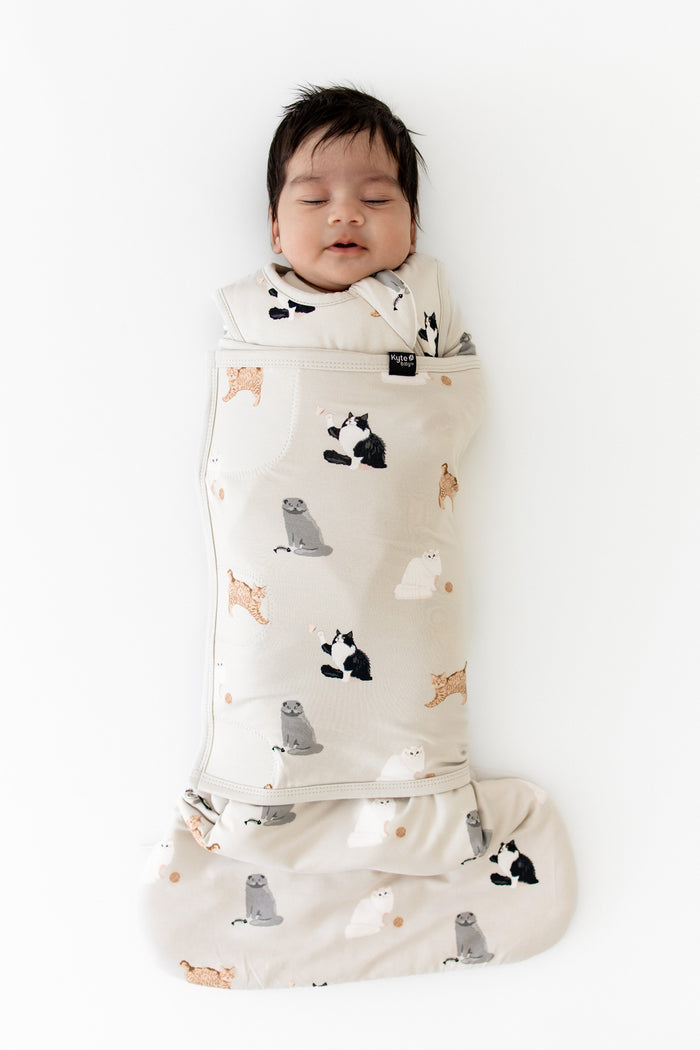 Sleeping newborn wearing the Sleep Bag Swaddler in Fluffy Cat 1.0