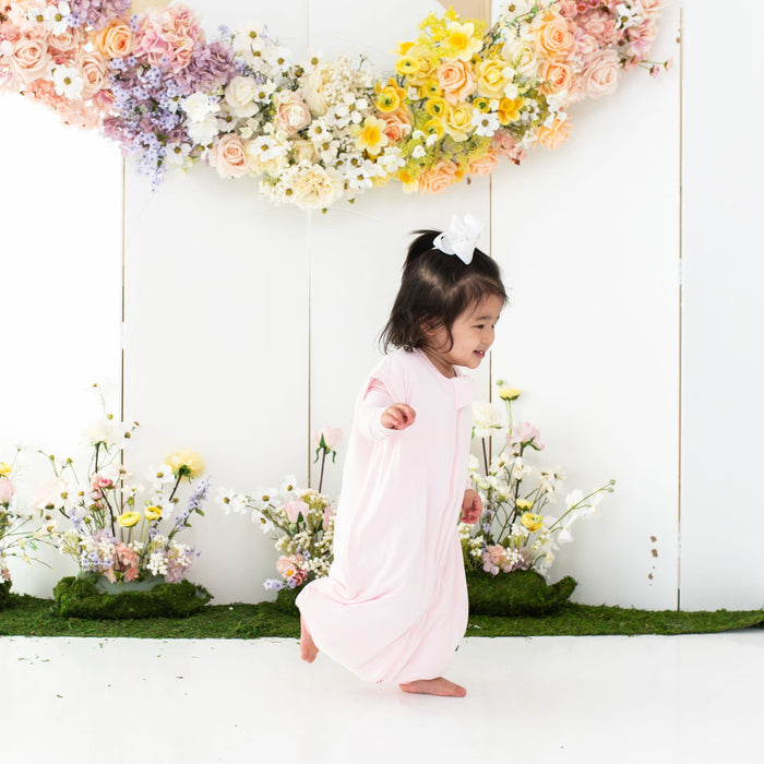 Toddler wearing Kyte Baby Sleep Bag Walker in Sakura 1.0