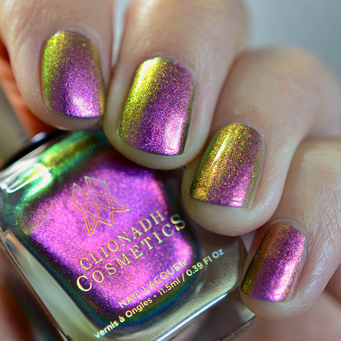 Close up shot of nails done with Smoulder Lite nail lacquer on fair skin tone holding the nail lacquer bottle