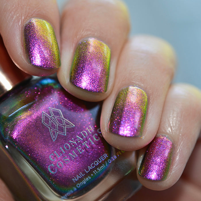 Close up shot of nails done with Smoulder Lite nail lacquer on fair skin tone holding the nail lacquer bottle