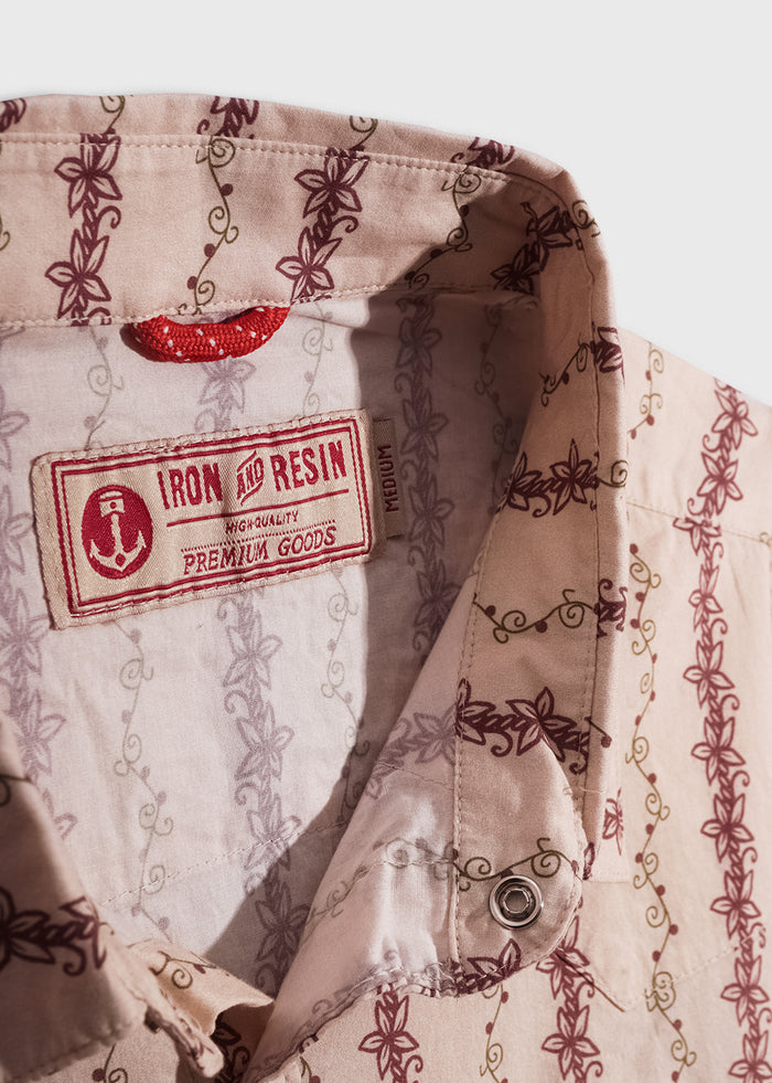 Close-up of a floral-patterned shirt collar with "Iron and Resin" label, highlighting premium quality and intricate design.