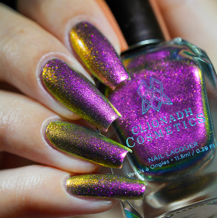 Close up shot of nails done with Smoulder Lite nail lacquer on fair skin tone holding the nail lacquer bottle