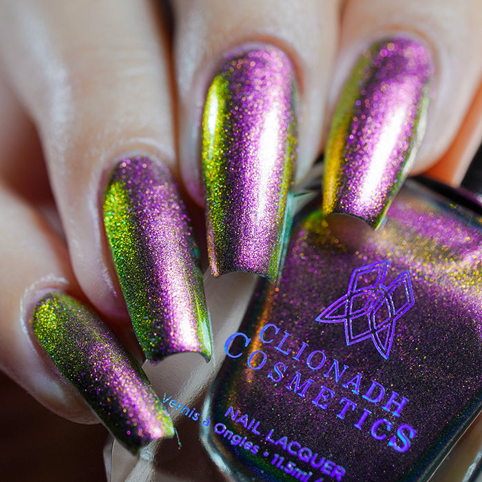 Close up shot of nails done with Smoulder Lite nail lacquer on fair skin tone holding the nail lacquer bottle