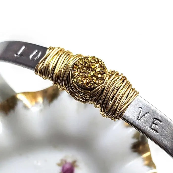 Stainless Steel LOVE Stamped Wire Wrapped Gold Druzy Cuff featuring a gold druzy stone and intricate wire wrapping.