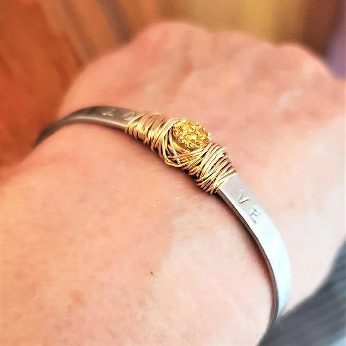 Stainless Steel LOVE Stamped Wire Wrapped Gold Druzy Cuff worn on wrist, showcasing handmade elegance.