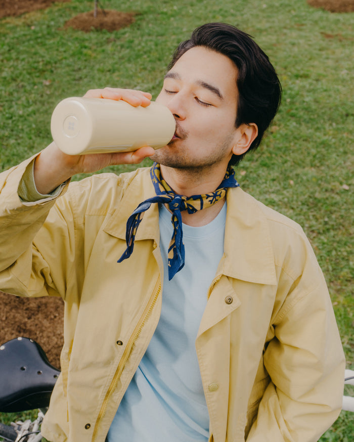 A man drinking from a pastel glossy waterdrop thermo steel bottle.
