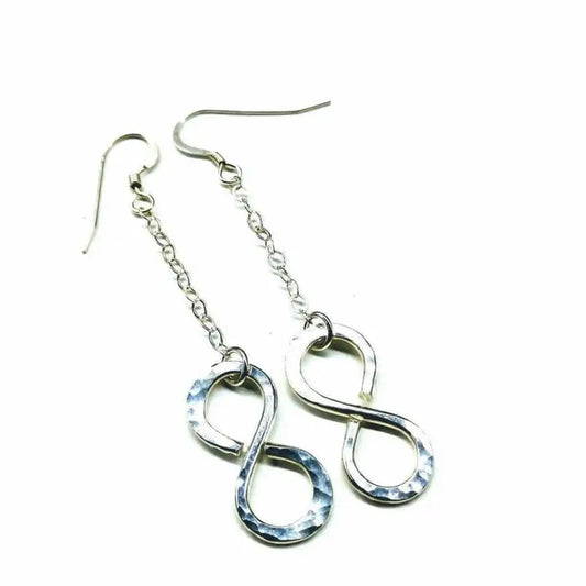 Sterling Silver Hammer Patterned Infinity Earrings hanging on a chain, showcasing their elegant design and artisan craftsmanship.