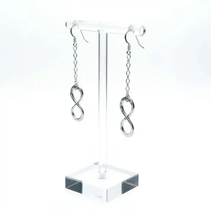 Sterling Silver Hammer Patterned Infinity Earrings displayed on a clear stand, showcasing their elegant design.