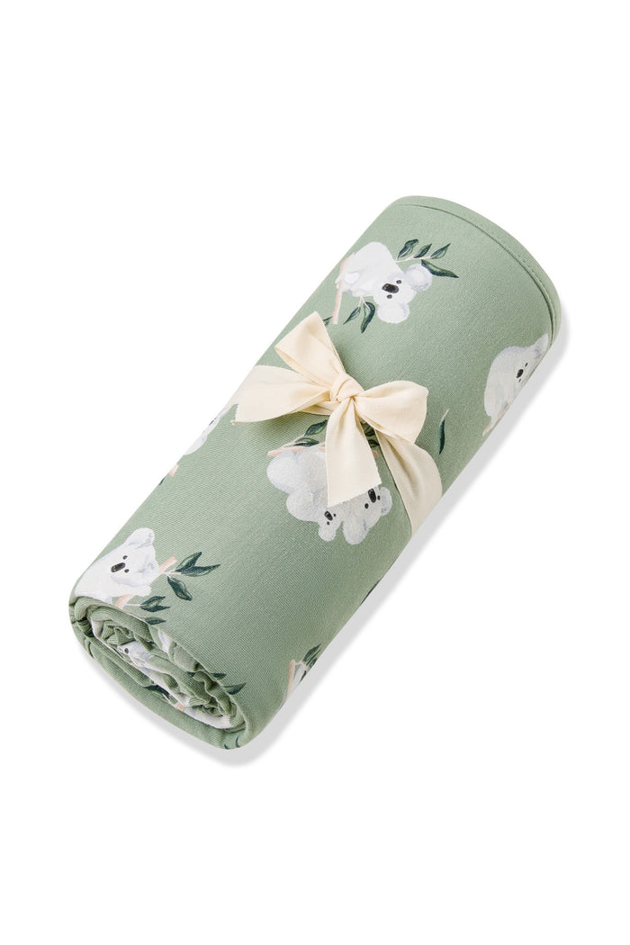 Swaddle Blanket in Koala rolled in its packaging tied with a linen bow