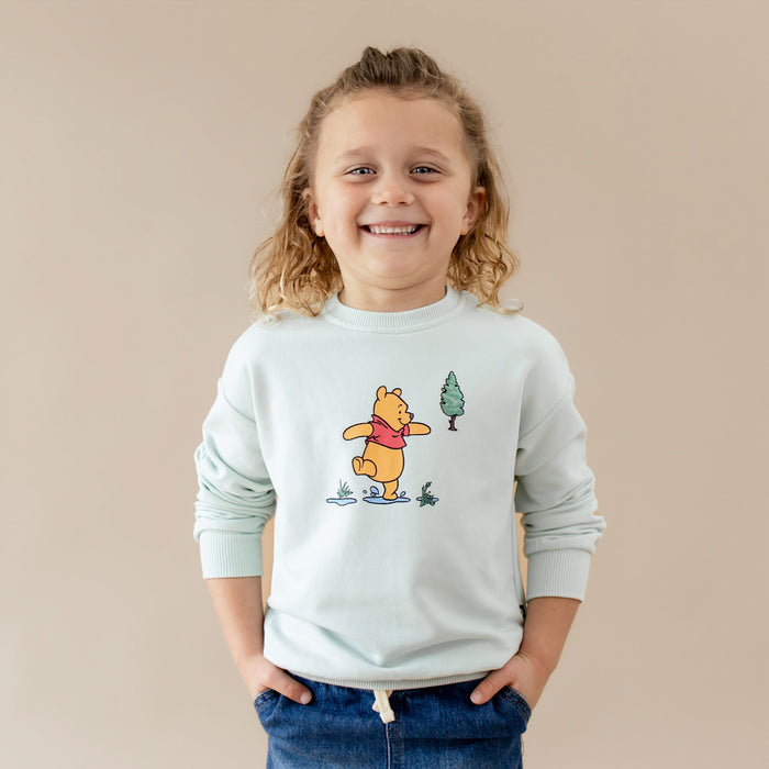 Smiling child wearing the Sweatshirt in Winnie the Pooh on Dew with their hands in he pockets of their jeans