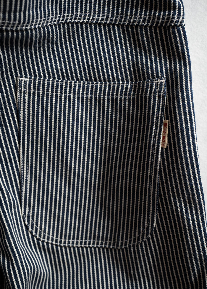 Close-up of blue and white striped fabric with a pocket, showcasing detailed stitching and texture.
