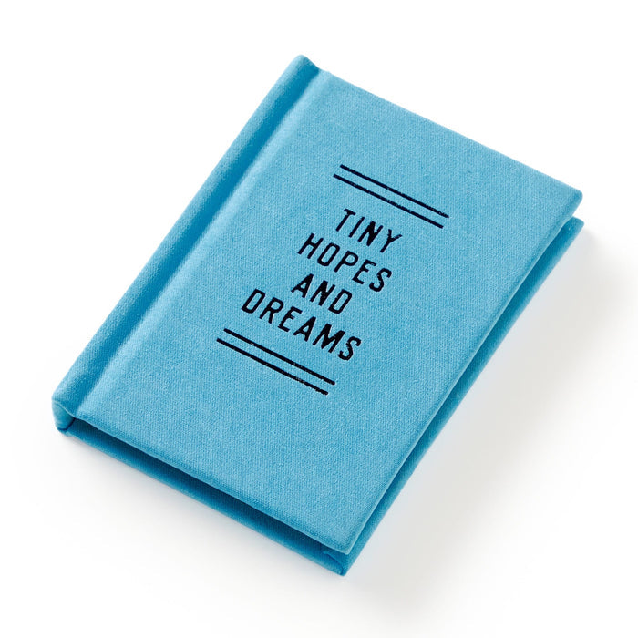 A small, hard-bound blue diary titled Tiny Hopes and Dreams by Brass Monkey, featuring black cover text, is displayed on a white background.
