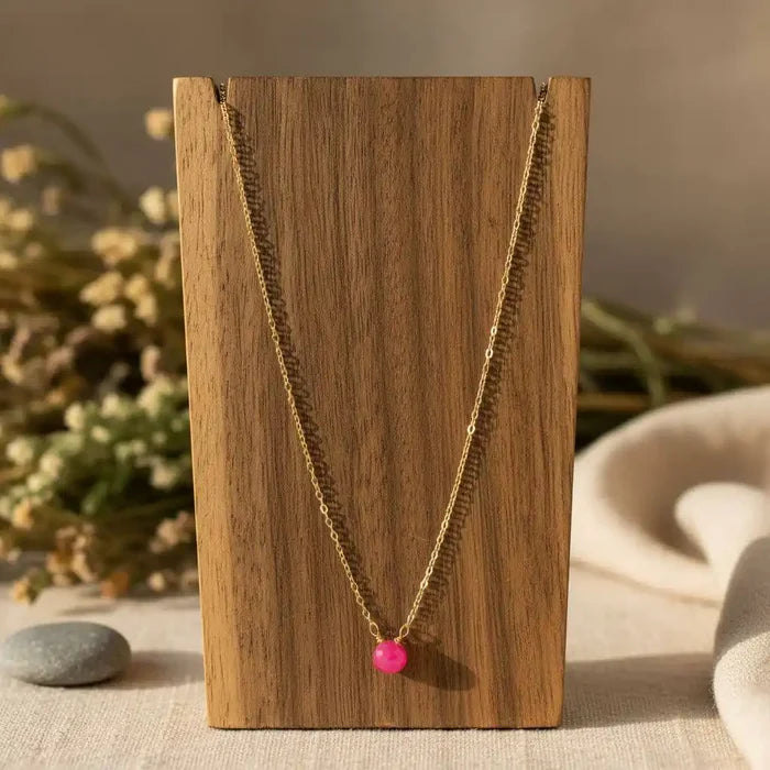 Tiny Hot Pink Chalcedony Gold Filled Necklace displayed on wooden stand with a vibrant hot pink chalcedony drop.