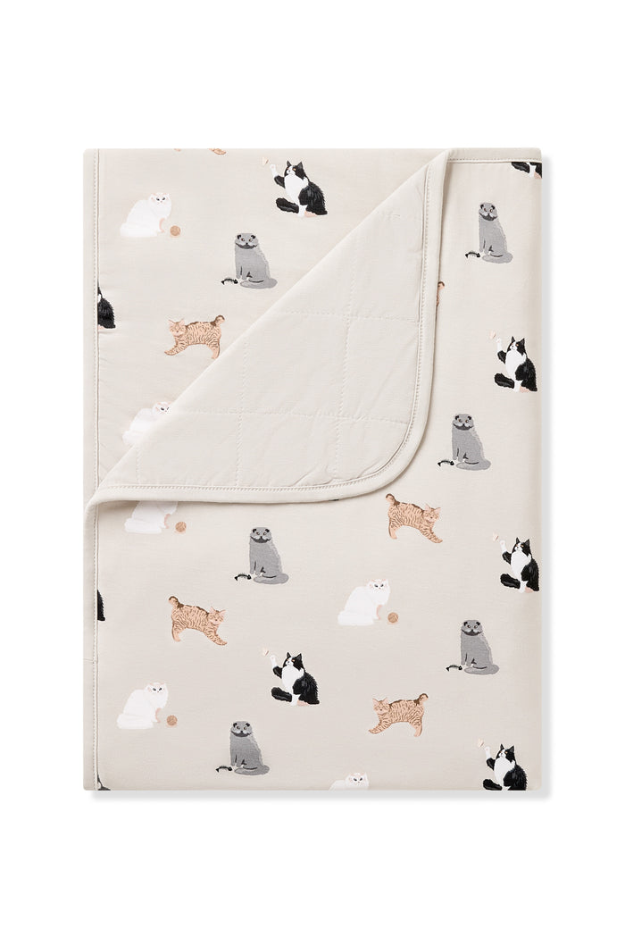 Toddler Blanket in Fluffy Cat 1.0 with the corner flipped down showing the light beige quilted backing