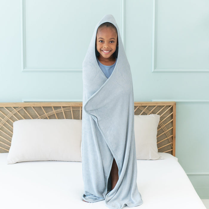 Child wrapped in Kyte Baby Toddler Hooded Bath Towel in Fog