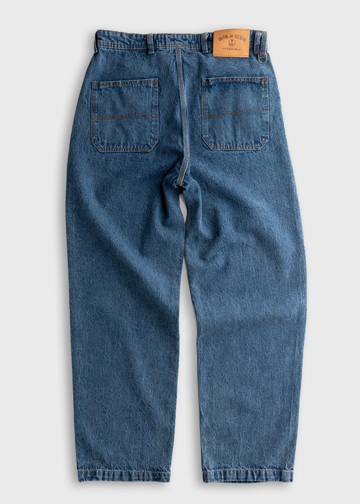 Blue denim jeans with two back pockets and a brown leather patch on the waistband, displayed on a light background.