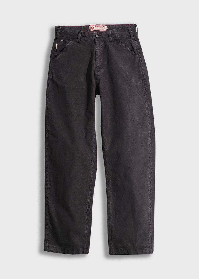 Black denim pants with a relaxed fit, featuring front pockets and belt loops, displayed on a white background.