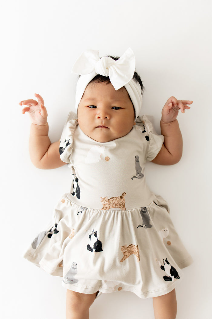 Close up of a newborn wearing the Twirl Bodysuit Dress in Fluffy Cat