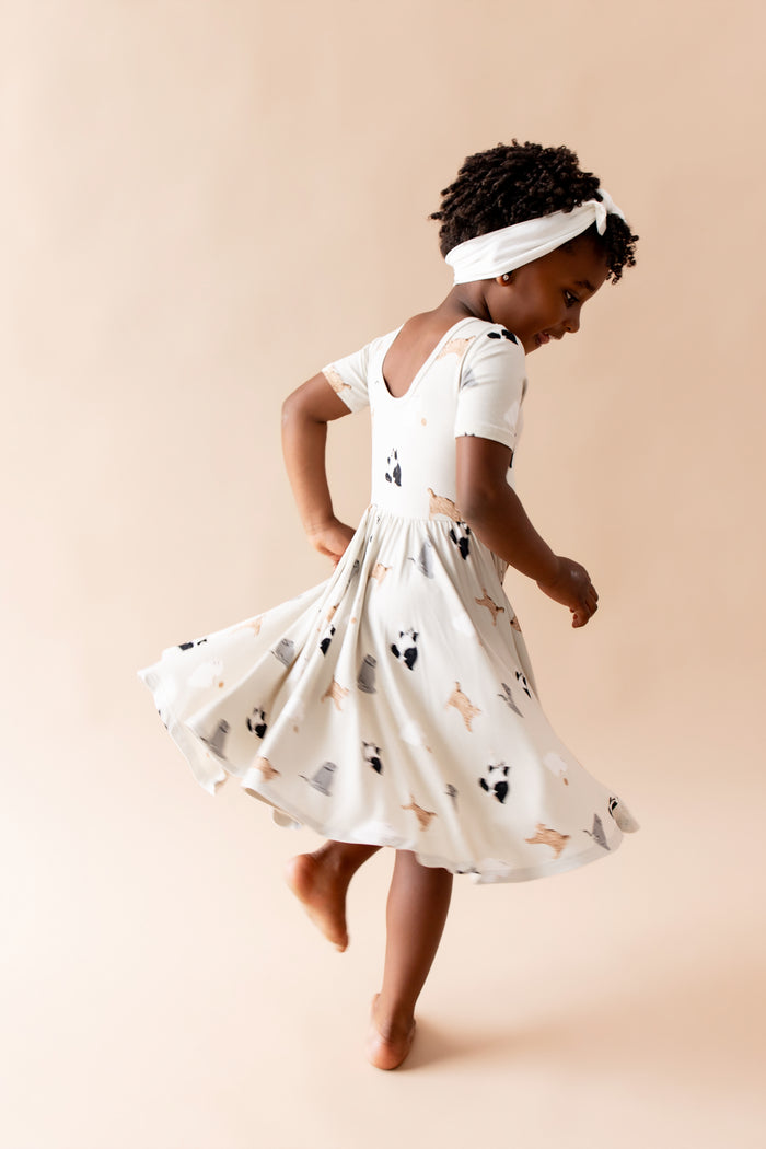 Young girl twirling wearing the Twirl Dress in Fluffy Cat showing the ballerina cut back