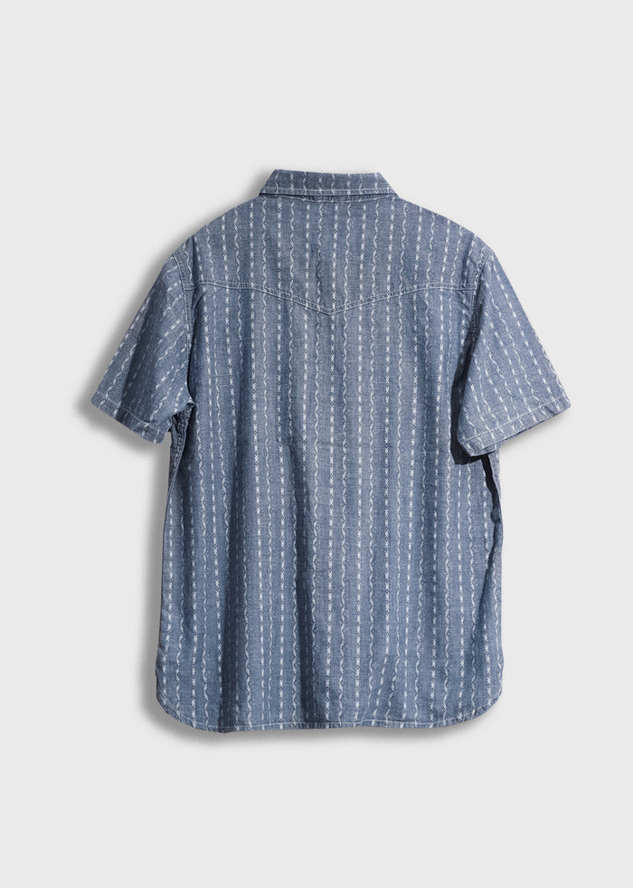 Blue short-sleeve shirt with white vertical stripes, back view. Simple design on a plain background. Casual and stylish.