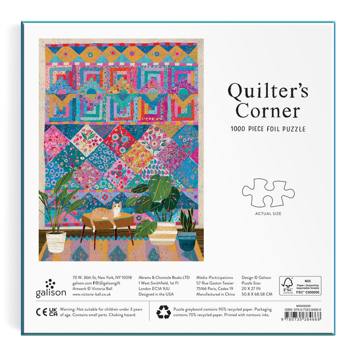 The image shows the box for the Victoria Ball Quilters Corner 1000 Piece Foil Puzzle, featuring a cozy room with a vibrant quilt tapestry, a cat on an armchair, and large green plants. The brand Victoria Ball appears at the bottom.