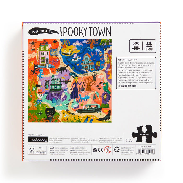 The back of the Welcome to Spooky Town 500 Piece Puzzle by Stephanie Birdsong displays colorful Halloween art with haunted houses, ghosts, bats, skeletons, black cats, pumpkins, puzzle details, and artist info.
