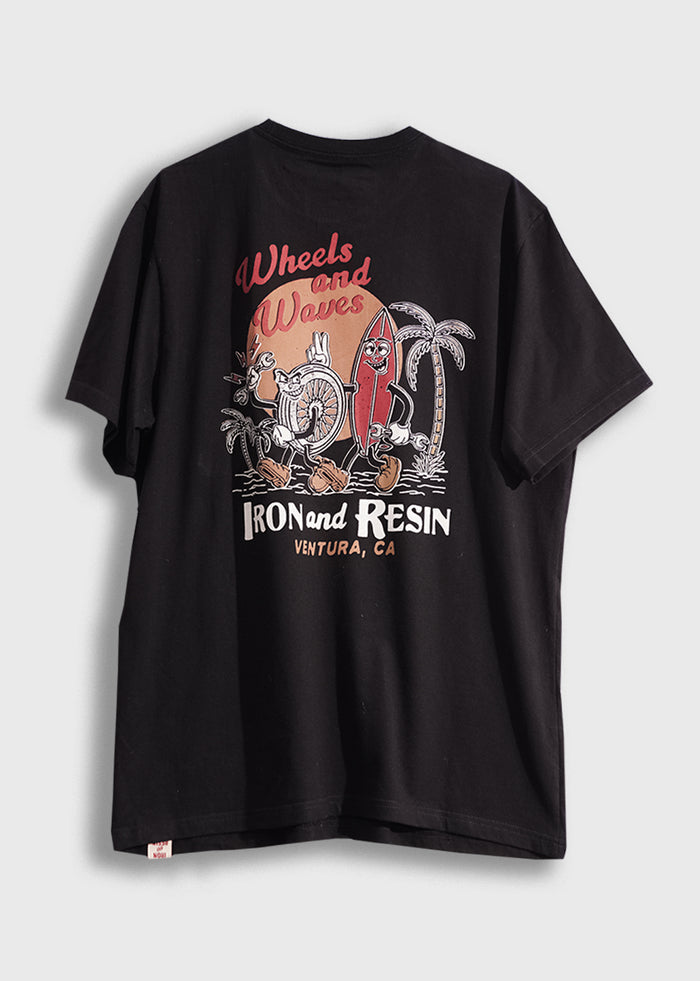 Black T-shirt with "Wheels and Waves" design featuring a surfboard and palm trees. Text: Iron and Resin, Ventura, CA.