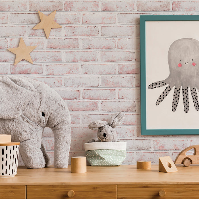 Tempaper's Whitewashed Brick Peel And Stick Wallpaper shown in a kids bedroom above a wood dresser and stuffed animals. #color_whitewashed