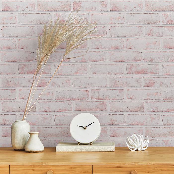 Tempaper's Whitewashed Brick Peel And Stick Wallpaper above a wood dresser with a clock and plant on top. #color_whitewashed